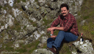 Ron on a cliff drinking scotch; the camera pans out and we can see the cliff overlooking the water