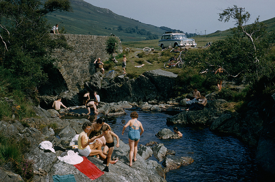 Bikes park near an arched stone bridge above bathers enjoying the water on Arran Island, Scotland, July 1965.Photograph by Robert Sisson, National Geographic