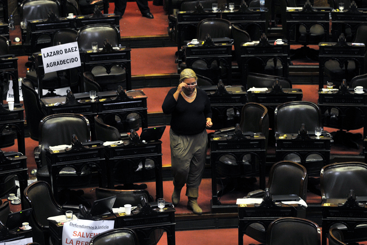 Elisa Carrió baja por uno de los pasillos de la Cámara de Diputados, sola entre las bancas vacías de la oposición. (Gustavo Ortiz)