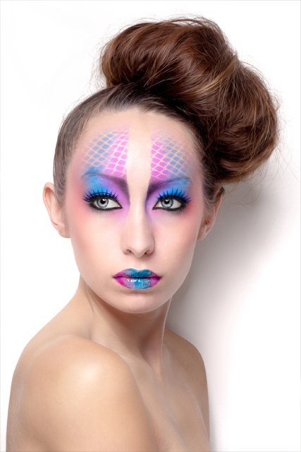 This a makeup look I did a few years back. It’s really simple to recreate. <br /> I used an airbrush, but the same technique can be achieve with eyeshadow. <br /> To get the print effect; <br /> Take a pair of fishnet tights, and stretch across the models face (you made need a hand, so ask your model to hold the tights in place) be sure that whichever way you position the diamond shapes, that you match them up as you work your way across the face / body. Otherwise it won’t be consistent. <br /> I sprayed two colours as you can see, and I used tape down the nose, to give me a perfect line. <br /> You use a sponge dipped in eyeshadow or body paint, and dab over the tights continually until you’re happy with the opacity of the colour. Then carefully pull the tights away and remove any defining tape. <br /> For the lips, you can mix the same eyeshadow colour with lipgloss like I did here. <br /><br /> Have fun! <br /><br /> MakeUp: Me (Shonagh Scott) <br /> Photography: Martin Higgs <br /> Model: Gina Negus
