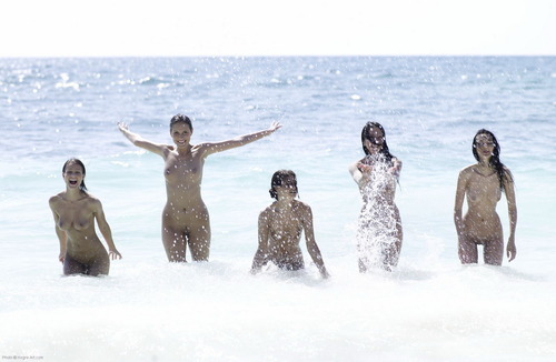 group of five nude girls splashing water in the ocean surf at slutsoft