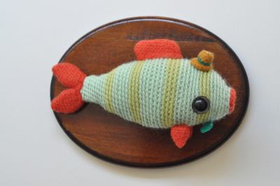 fish taxidermy for peggy.<br /><br /><br /><br /><br /><br />
crocheted and hand felted. i didn&#8217;t felt the body so the texture of the stitches would make him look scaly.<br /><br /><br /><br /><br /><br />
materials: wool yarn, eyeballs, stuffing, wood plaque, varnish