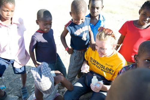 A Scientology Volunteer Minister plays with children in Haiti.