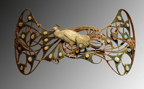 René Lalique (1860-1945)France, c.1898-1900 Gold, enamel, opals, diamonds “Of all the animals reproduced in the work of Lalique, the peacock is perhaps regarded as the most emblematic of the spirit of Art Nouveau, and it is a recurring theme in the artist’s work, whether isolated as here or in pairs in other jewels. The theme is again very representative of Symbolist painting, as a symbol par excellence of natural beauty in all its splendour. This pectoral is made up of an enormous, articulated peacock in enamelled gold in tones of blue and green simulating the feathers of the bird which have small cabochon-oval opals set here and there. Sinuous movement of the feathers in the tail, turned to the left, is enriched by a balanced composition of diamonds, of various sizes, that finish off the piece on both sides.”