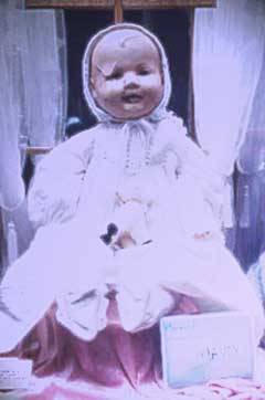 fuckyeahthebizarre:

Mandy the Haunted DollMandy the Haunted Doll lives at the Quesnel                                        Museum, which is located on the Old Cariboo                                        Gold Rush Trail in British Columbia. There                                        she is just one of over thirty thousand                                        artifacts on display for the public, but                                        there is little doubt that she is the most                                        unique.
Mandy was donated to the museum in 1991.                                        At that time her clothing was dirty, her                                        body was ripped and her head was full of                                        cracks. At that time she was estimated to                                        be over ninety years old. The saying around                                        the museum is, “She may seem like                                        an ordinary antique doll, but she is much                                        more than that.”
The woman who donated Mandy, also called                                        Mereanda, told the museum curator that she                                        would wake up in the middle of the night                                        hearing a baby crying from the basement.                                        When she investigated, she would find a                                        window near the doll open where it had previously                                        been closed and the curtains blowing in                                        the breeze. The donor later told the curator                                        that after the doll was given to the museum,                                        she was no longer disturbed by the sounds                                        of a baby crying in the night.
Some say Mandy has unusual powers. Many                                        speculate that the doll has acquired these                                        powers over the years, but since little                                        is known of the doll’s history nothing                                        can be said for certain. What is certain                                        is the unusual effect she seems to have                                        on everyone around her.
As soon as Mandy arrived at the museum,                                        staff and volunteers began to have weird                                        and unexplainable experiences. Lunches would                                        disappear from the refrigerator and later                                        be found tucked away in a drawer; footsteps                                        were heard when no one was around; pens,                                        books, photos and many other small items                                        would go missing – some were never                                        found and some turned up later. The staff                                        passed these events off as absent-mindedness,                                        but this did not account for everything. Mandy did not have a permanent “home”                                        inside the museum when she first arrived.                                        She was placed in the museum entrance way,                                        facing the public, and visitors would stare                                        and talk about the doll with the cracked                                        and broken face and sinister smile. Eventually,                                        Mandy was moved to another part of the museum                                        where she was carefully placed alone in                                        a display case because museum staff had                                        been told that she should not be placed                                        with other dolls because she would harm                                        them.
Since her permanent placement there have                                        been many stories about encounters with                                        the haunted doll. One visitor was videotaping                                        Mandy only to have the camera light go on                                        and off every 5 seconds. When the visitor’s                                        camera was turned on another exhibit, it                                        functioned just fine. (It is interesting                                        to note that the same thing often happens                                        when visitors try to photograph Robert the                                        Doll in his Key West museum home.)
Some visitors are very disturbed by the                                        doll’s eyes, which they say appear                                        to follow them around the room. Others claim                                        to have seen the doll actually blink, and                                        still others say they have seen the doll                                        in one position and minutes later she will                                        appear to have moved.
Although they’re used to it by now,                                        museum staff and volunteers still prefer                                        not to be the last one working or locking                                        up the museum at the end of the day. (source)
