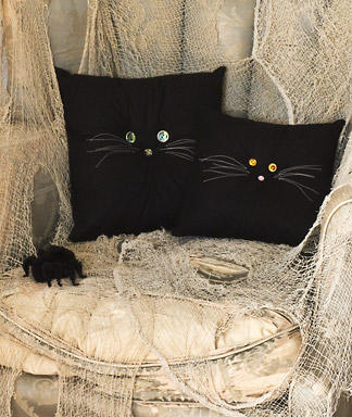 Halloween Crafts: Black Cat Pillows 
Turn ordinary black pillows into creative Holiday decorations with crystal buttons and just two strands of floss
Skill Level: Beginner
Materials: Hand sewing needles; black thread; 1⁄2-inch black or pink button; black pillow (about 12 inches across in any fabric as desired); two 1⁄2-inch crystal buttons; white embroidery floss.
Directions:
1. Thread a long needle with black thread; sew the 1⁄2-inch button to the center of the pillow, stitching all the way through and pulling the thread tight, forming the cat’s nose.
2. Sew crystal buttons above nose to make eyes.
3. Thread an embroidery needle with 2 strands of floss. To make whiskers, make a small stitch on one side of nose; tie thread ends together and trim to about 2 inches long. Make several more whiskers on each side of nose in this way