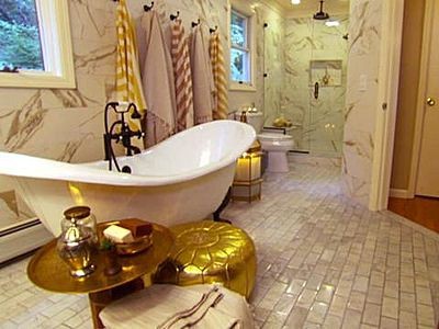 Turkish inspired bathroom done by Genevieve Gorder with a gold moroccan pouf