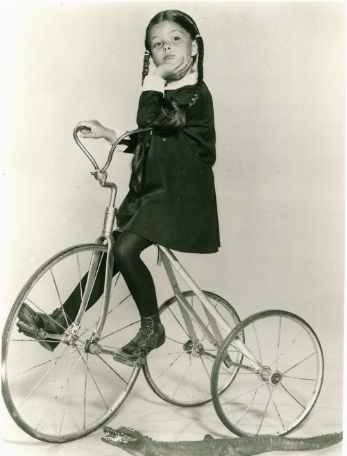 Lisa Loring rides a trike.