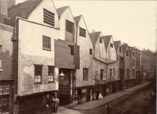 Bermondsey Street, Bermondsey, London, 1880: As you would expect, Bermondsey Street is now changed completely from this scene of rickety and jagged buildings cobbled together from various materials. Bermondsey was a very poor area throughout the Victorian era, and would have been an extremely unpleasant place to visit, what with its tanners and glue factories. Many social explorers wrote about the area and the smell caused by the rotten water in the Thames. In this picture, you can see a man in a top hat which actually makes him taller than the doorway of the shop he is standing in front of; indeed, all of the shops along the street look small, dark and dingy - much like Bermondsey itself in the nineteenth century.