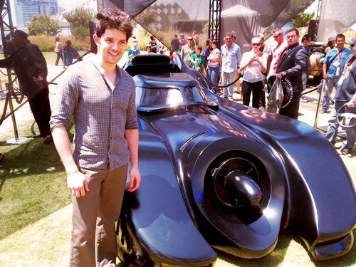 the-eyes-of-merlin:

If no one is going to post Colin next to the Batmobile then I will. One of my two favourite things. Katie is in the background, btw. [x]

&#8220;Quick, to the Batmobile!&#8221;
