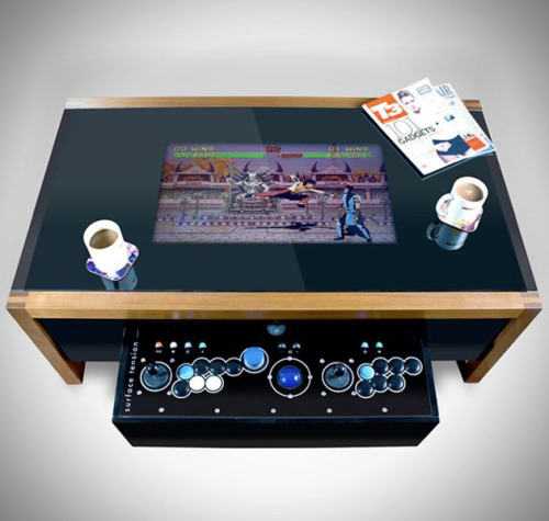brain-food:

Retro Arcade Table by Surface Tension
This wood constructed coffee table comes packed with a built in computer that can be specified to your liking along with 100 licensed games from Midway, Taito, and Atari. The MAME compatibility allows users to play all of their own retro arcade games as well. The 6mm toughened glass reveals your choice of either a 19 inch or 26 inch LCD monitor, while the high quality joystick is concealed within a hidden drawer. 

HERMOSO!