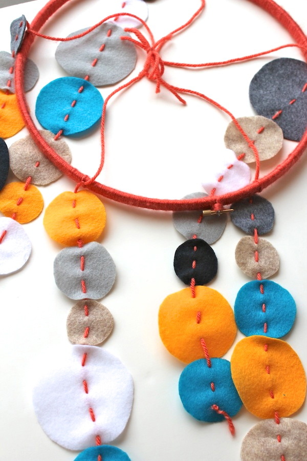 baby mobile made of modern felt circles embroidery hoop and yarn