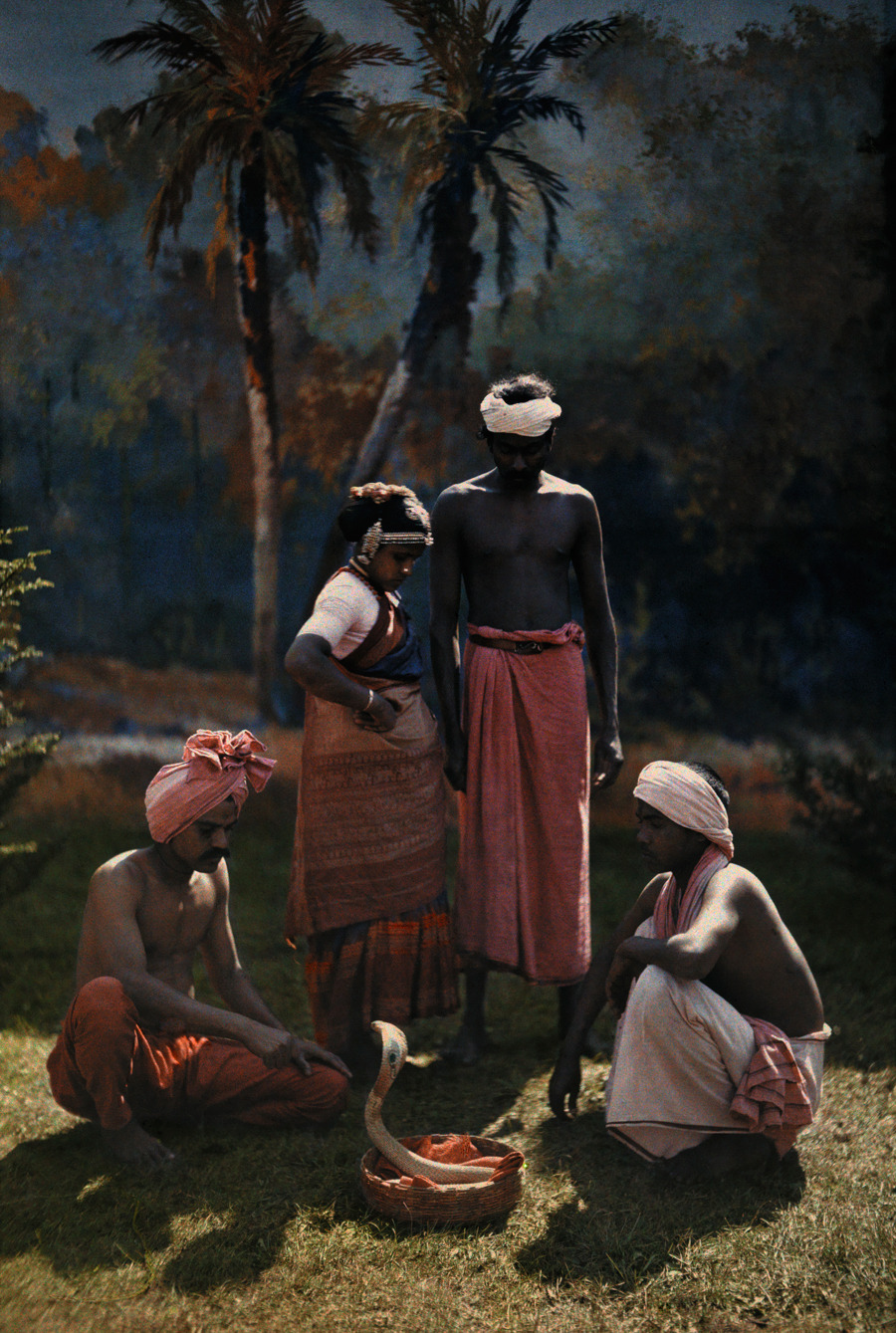 A group of people gather round and watch a snake charmer at work in India, 1923.Photograph by Hans Hildenbrand, National Geographic