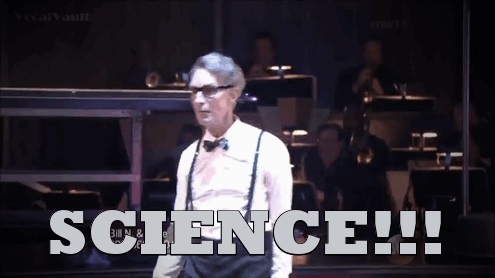 Bill Nye the Science Guy stands center frame in a while button up shirt, black suspenders, and classic bow tie. He throws his arms up and head back as the lights flash. The word 'SCIENCE!!!' is along the bottom of the image in gray.