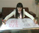 Rapariga escreve ao mesmo tempo com as duas mãos em idiomas diferentes