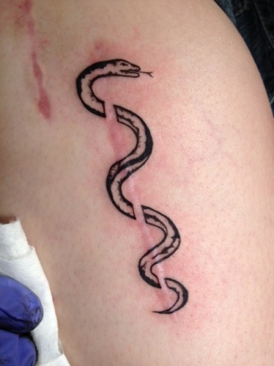 This is the Rod of Asclepius, the staff that the Greek God of Healing carried. It wraps around an incision scar, and it is a symbol of healing for the bone disease that I have lived with most of my life.</p>
<p>It was done by Chris Escobedo of Elite Tattoos in Phoenix, Arizona.